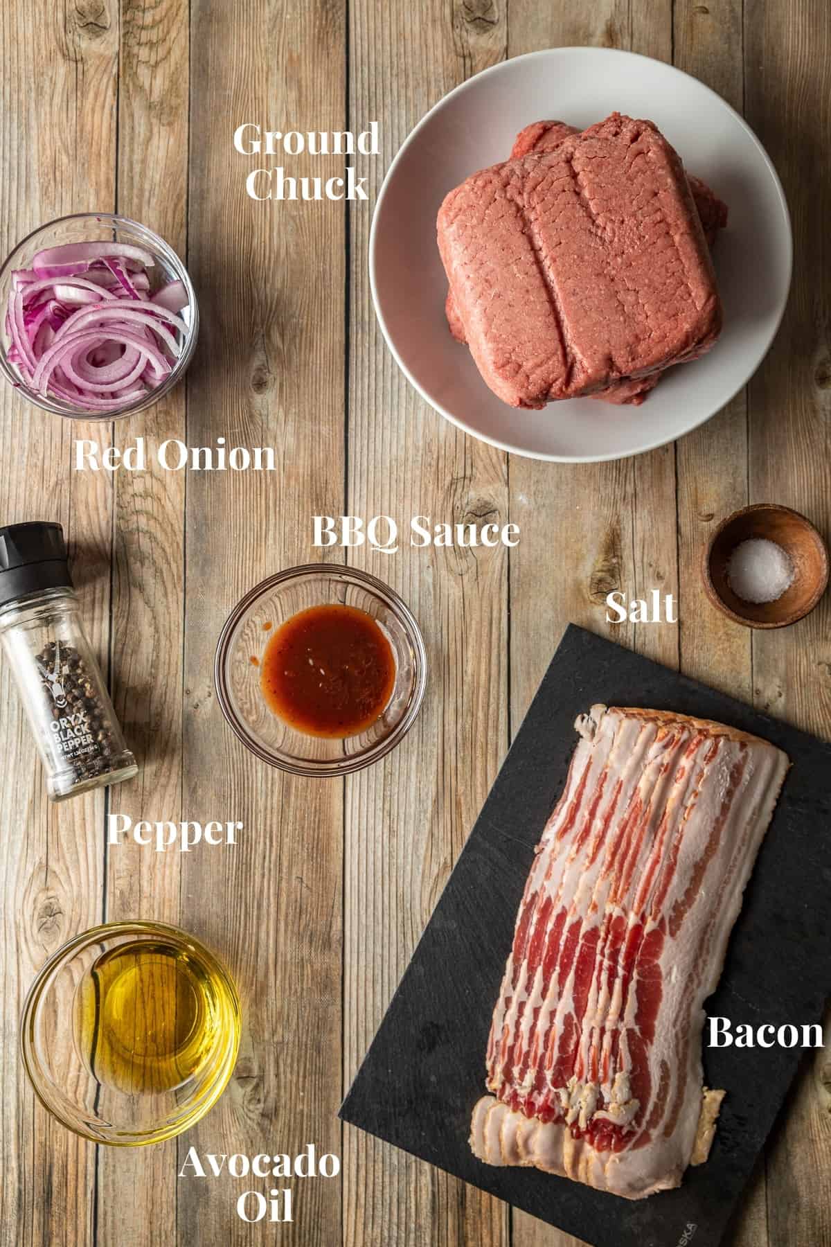An overview shot of the ingredients needed for smash burgers with bacon and onions.