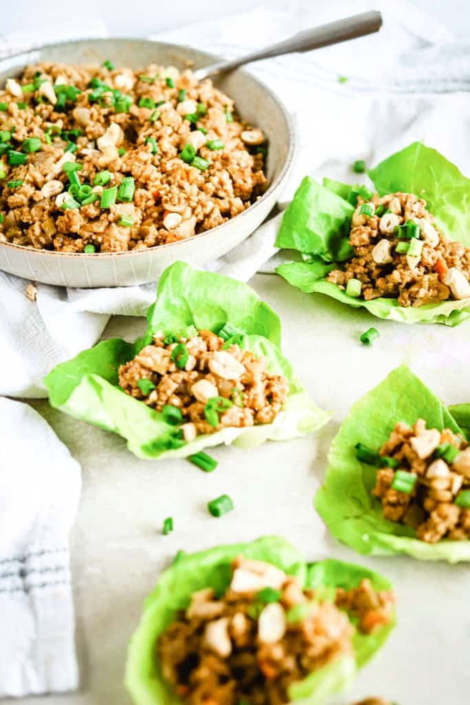 A bowl of chicken lettuce wrap filling and lettuce wraps