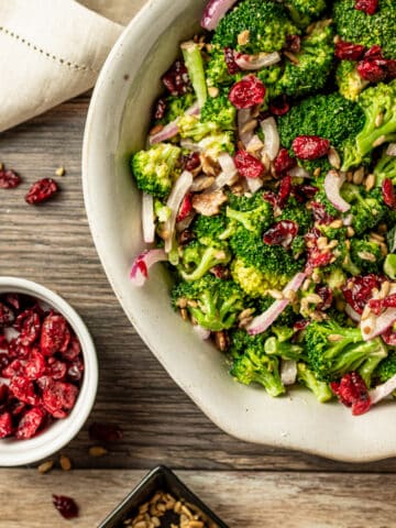 An overview shot of paleo broccoli salad with bacon on a wood background