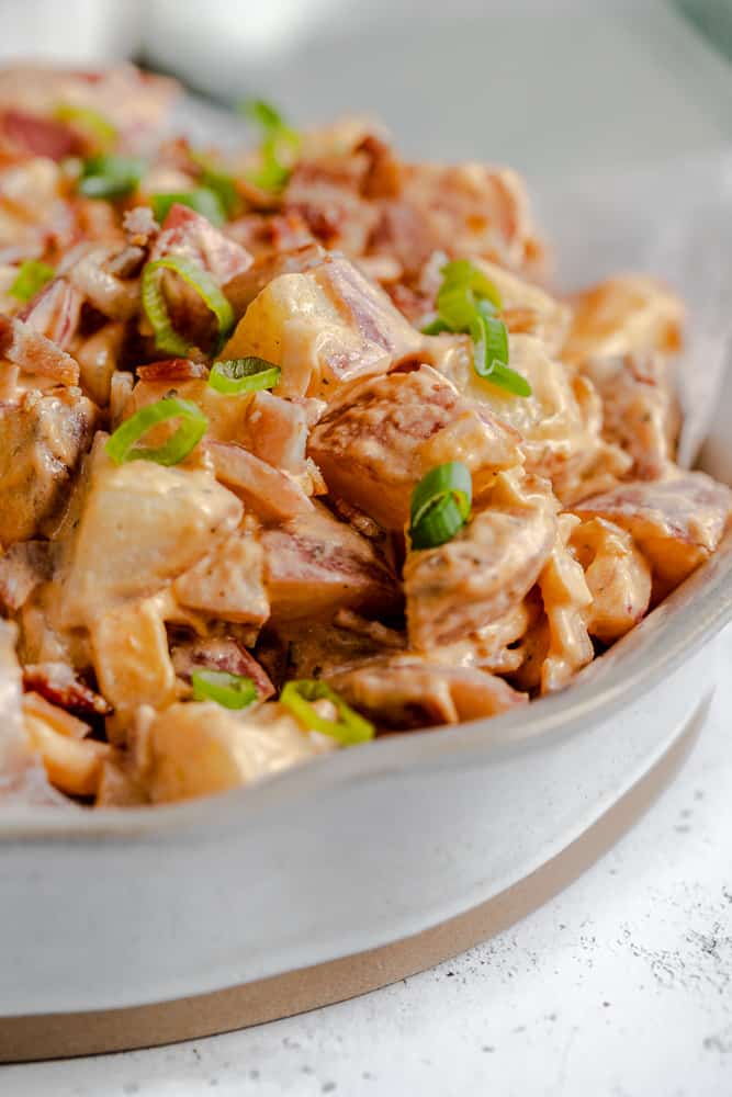 A close up view of buffalo ranch potato salad in a bowl