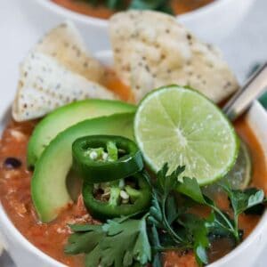 A top view of two bowls of chicken tortilla soup