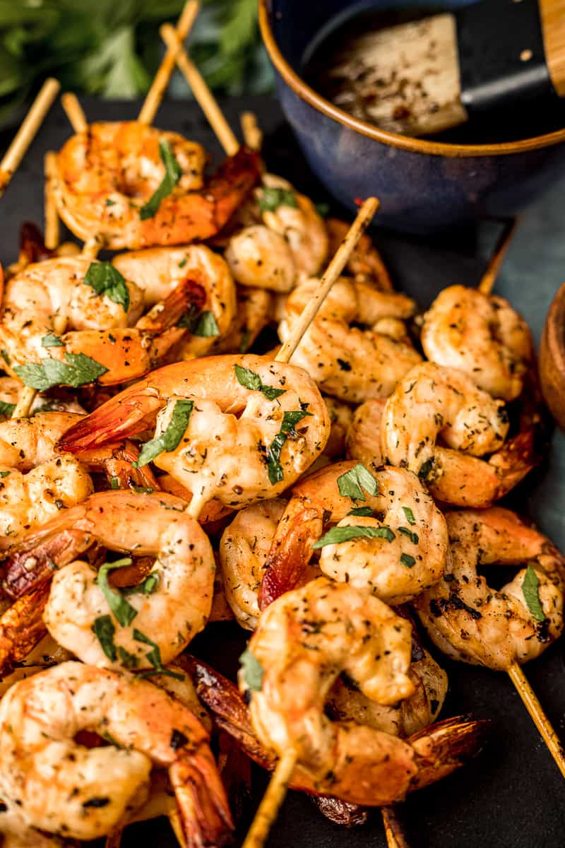 A close up view of smoked shrimp skewers next to Whole30 complaint marinade