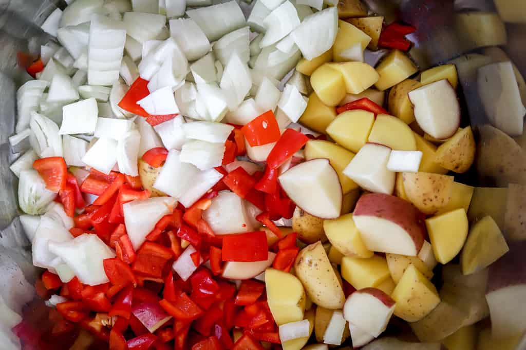 Top view of chopped onions, peppers and potatoes
