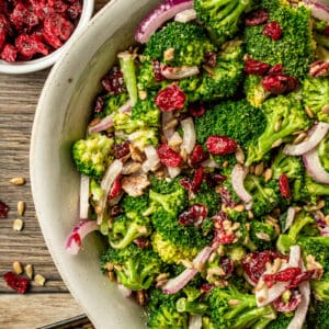 An overview shot of paleo broccoli salad with bacon on a wood background