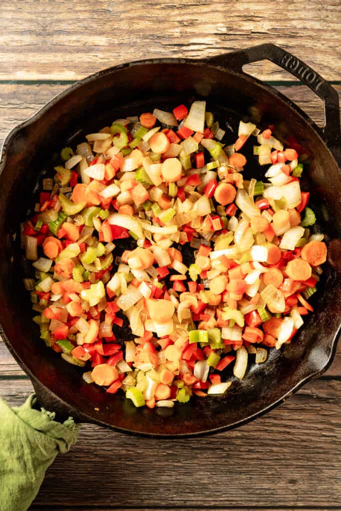 An overview shot of sauteing veggies for shepherds pie in a cast iron pan