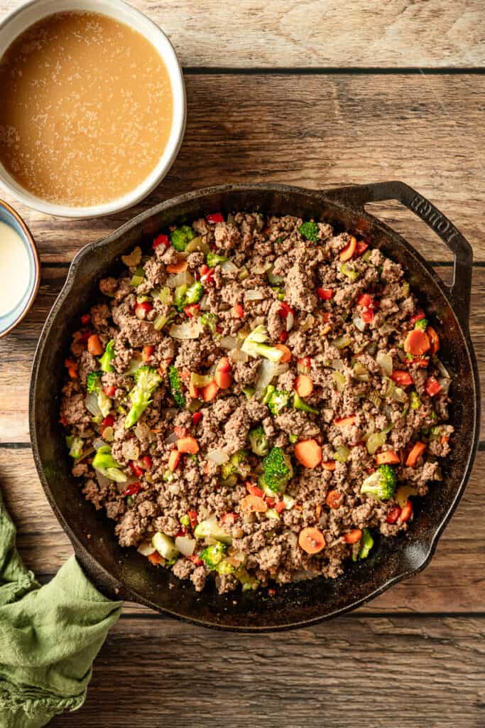 An overview shot of browning minced meat for shepherds pie in a cast iron pan