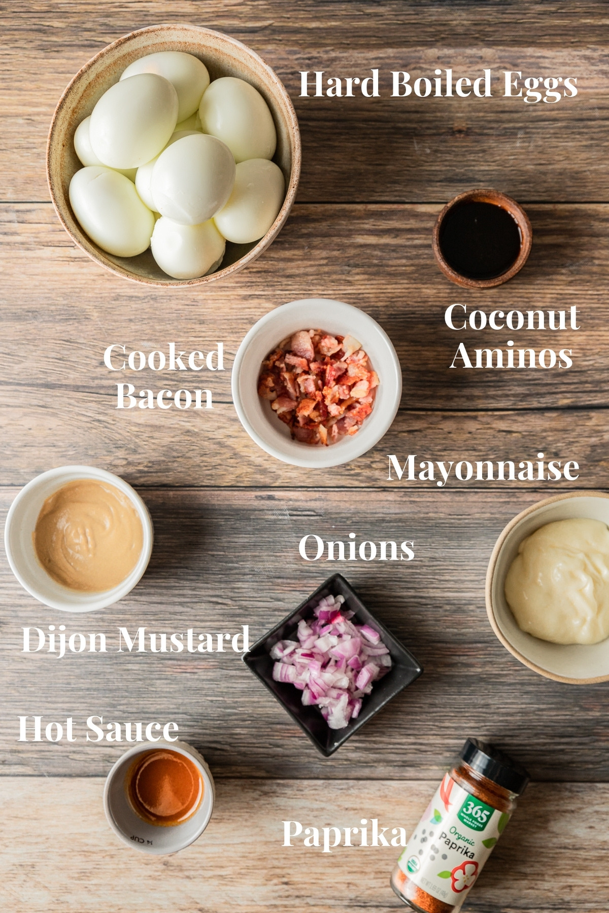 An overview shot of the ingredients needed for smoked deviled eggs on a wood background