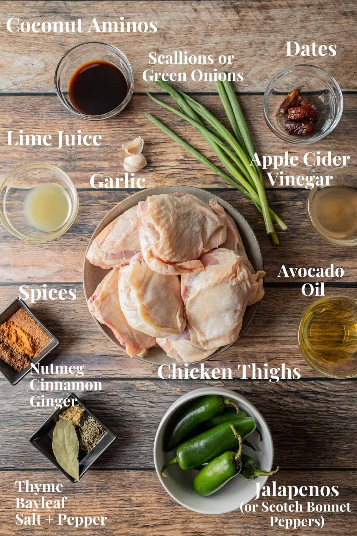 An overhead shot of the ingredients needed for jerk chicken thighs on a wood background.