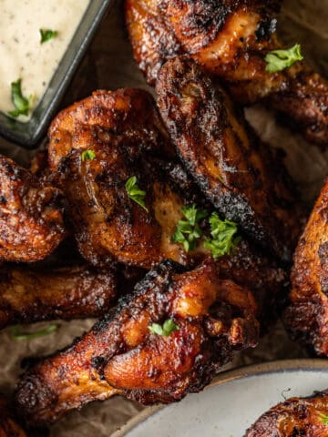 An overview shot of dry rub chicken wings topped with parsley and served with ranch.