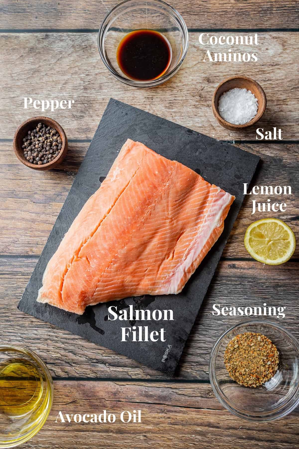 An overview shot of the ingredients needed for smoked salmon on a wood background.