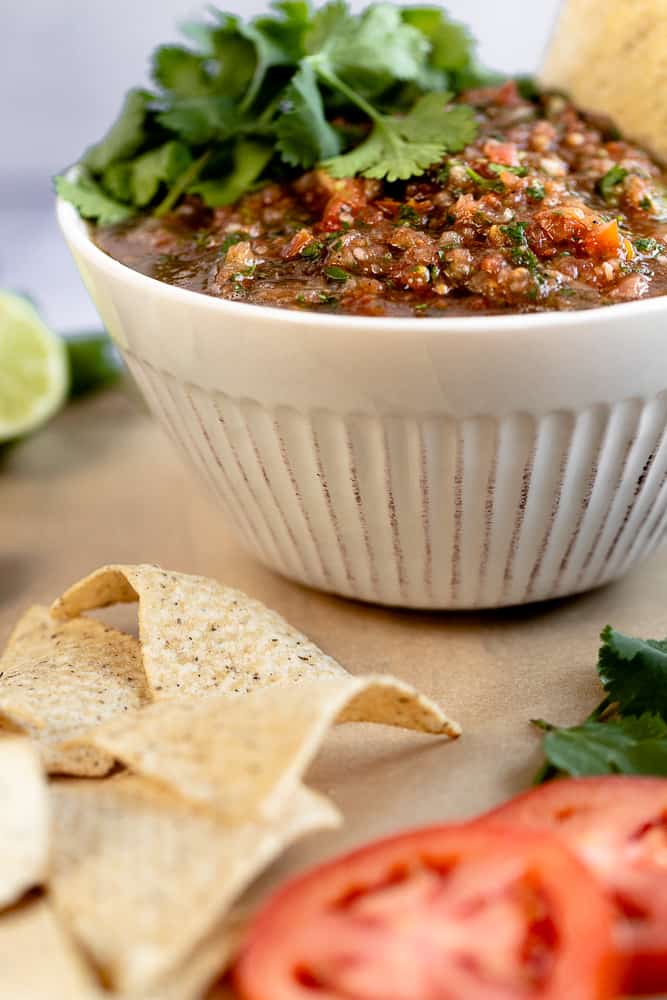 A close up of a bowl of salsa topped with cilantro