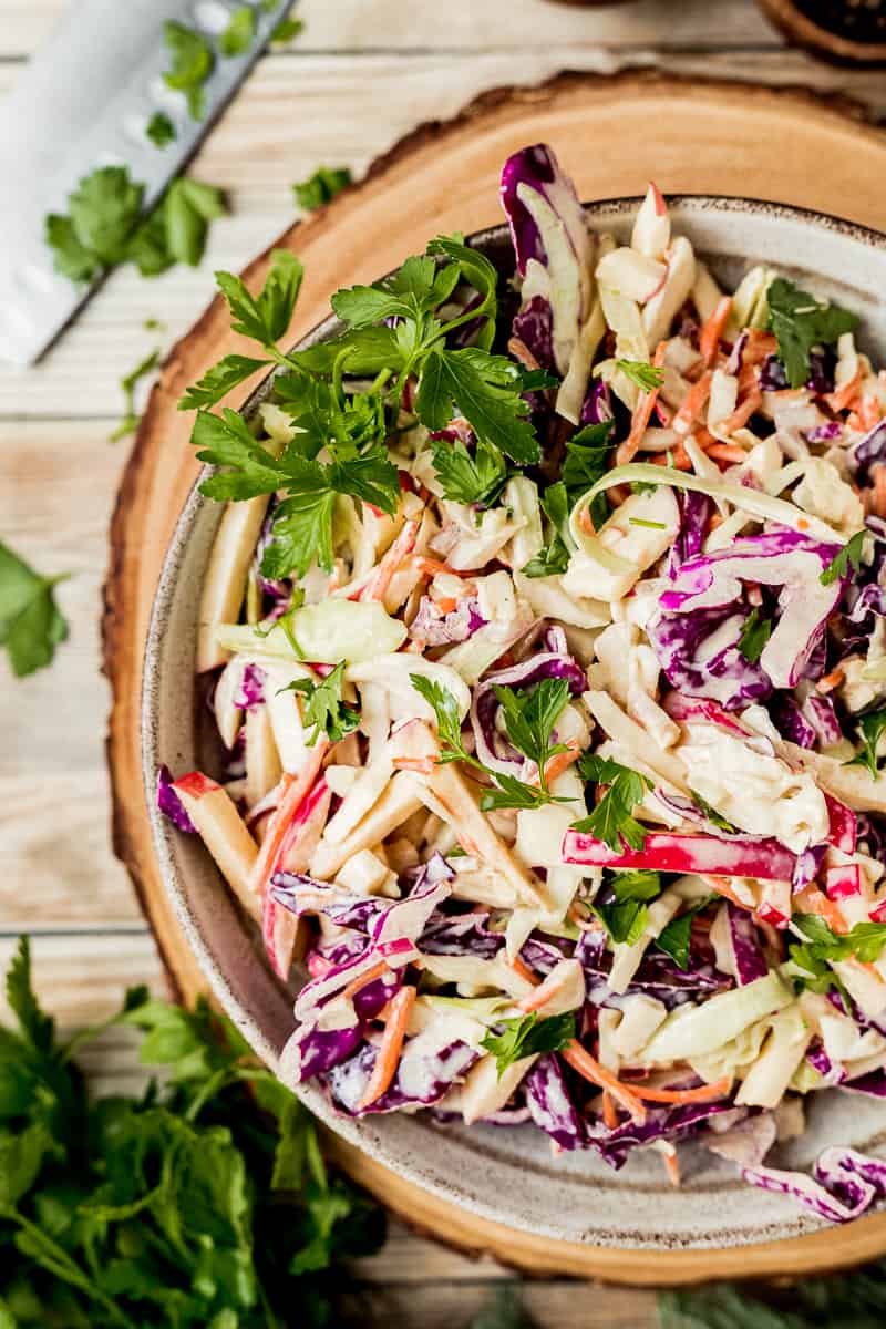 An overview shot of a bowl of Whole30 coleslaw on a wood background