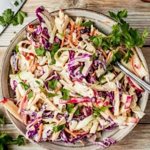 An overview shot of a bowl of Whole30 coleslaw on a wood background